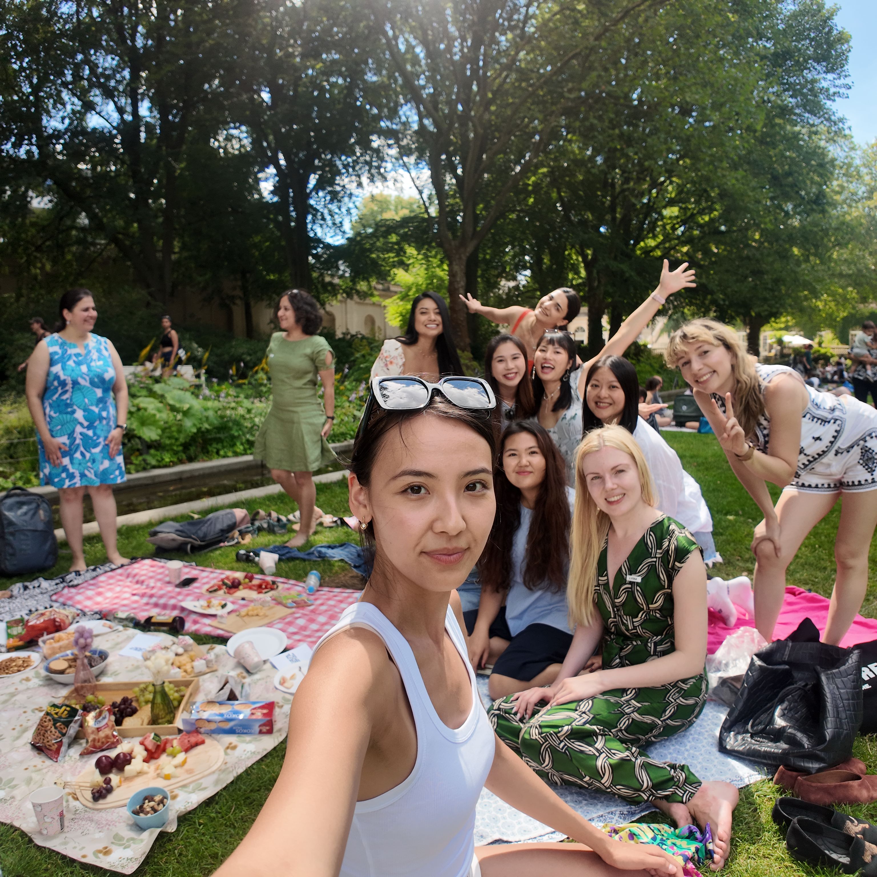 A baesh picnic in the park: a group of women smiling on picnic blankets